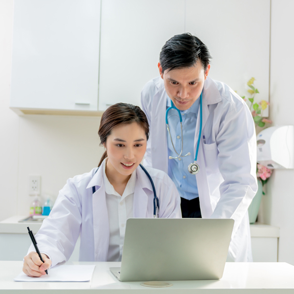 asian doctor man woman are working together by using looking notebook computer